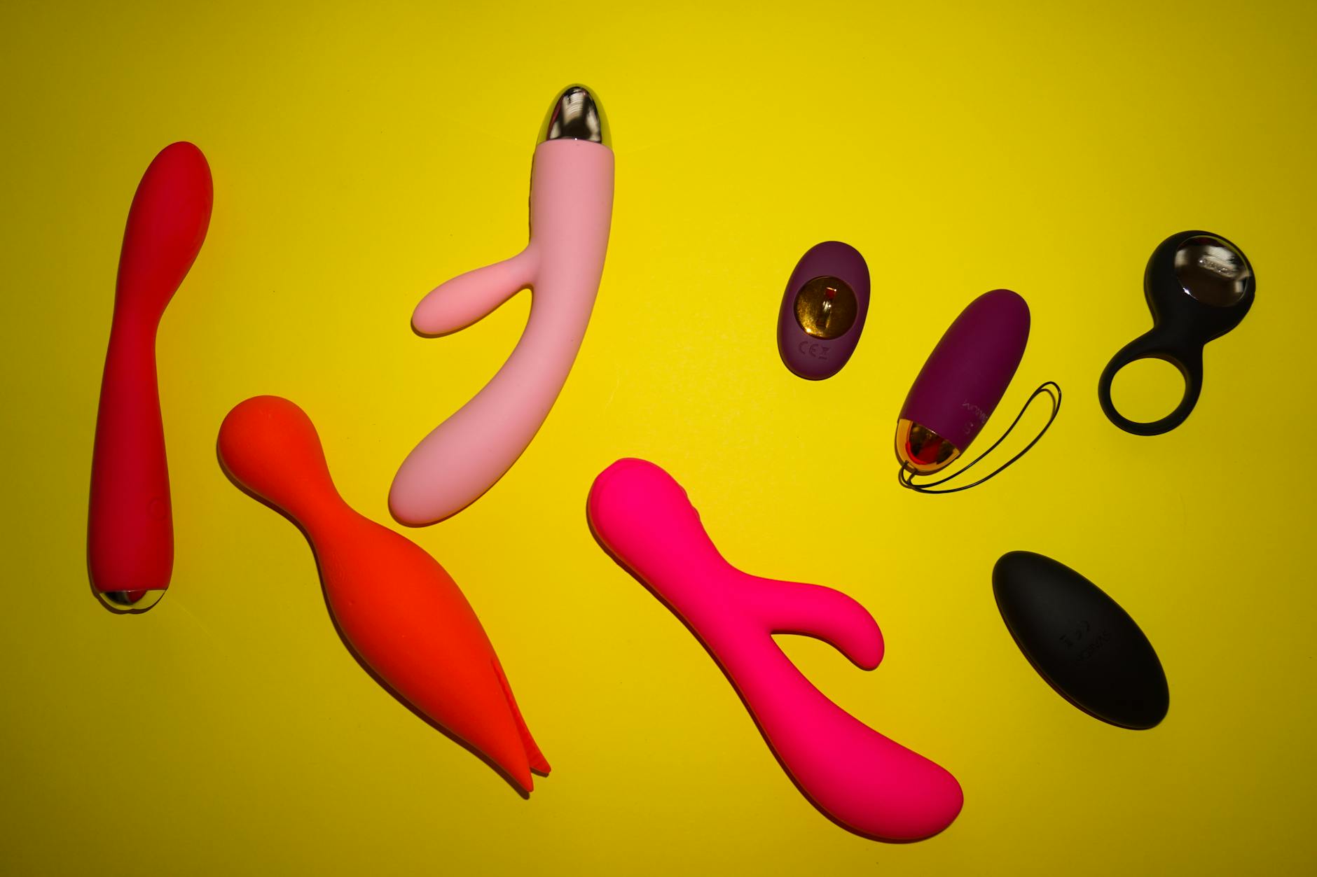 Collection of colorful lemon and citrus-shaped clitoral vibrators and suction toys on a bright yellow background